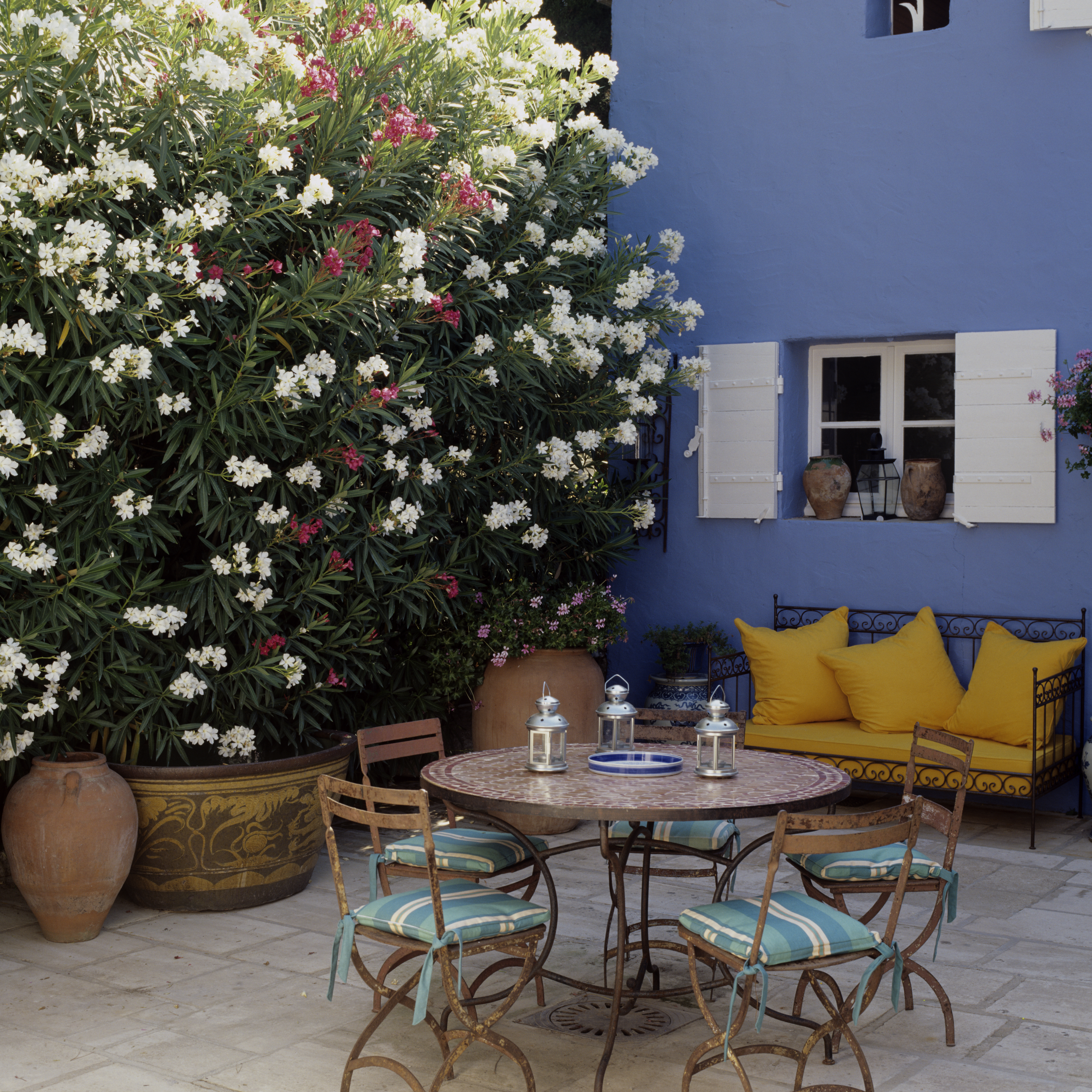 Fachada de casa com paredes em um tom azul mais fechado e janela de cor branca.