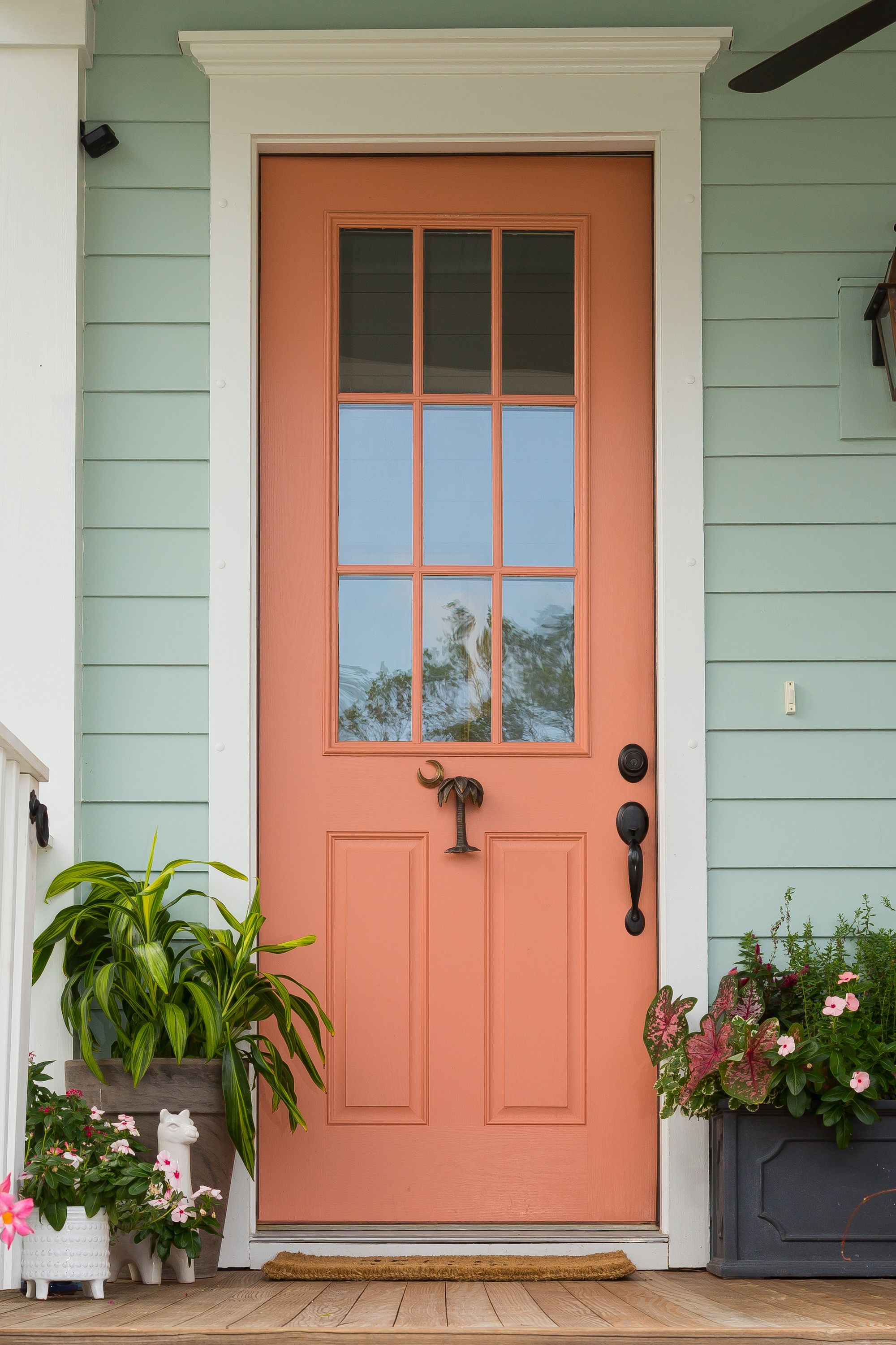 Fachada de casa com uma combinação de laranja (porta) e verde (parede).