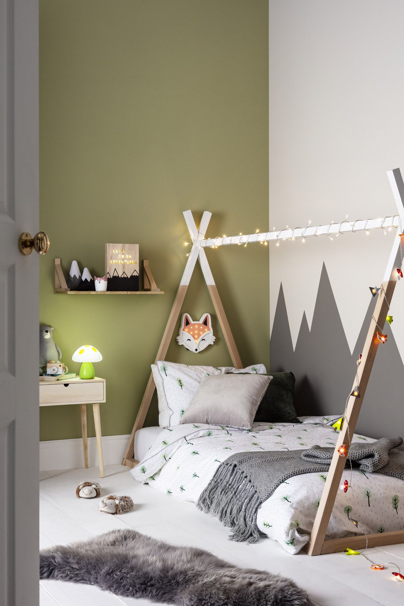 Quarto infantil com parede de trás pintada com um verde natural médio e a outra com tons de cinza.