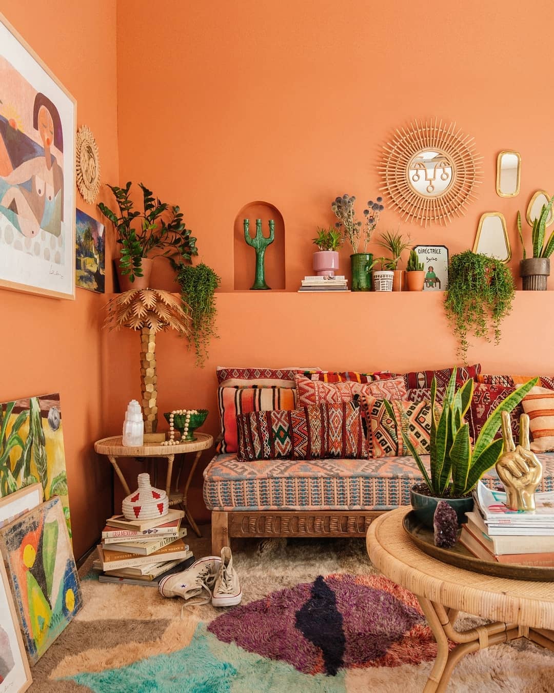 Sala com paredes pintadas com um tom de laranja vibrante e com decoração de estilo boho.